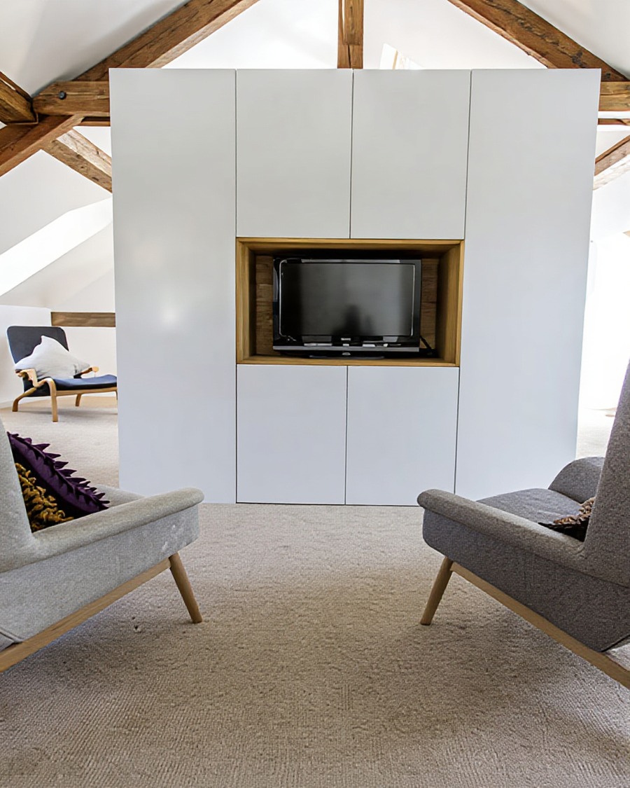 Attic conversion sitting room with exposed timber trusses and built-in joinery, Auld family extension